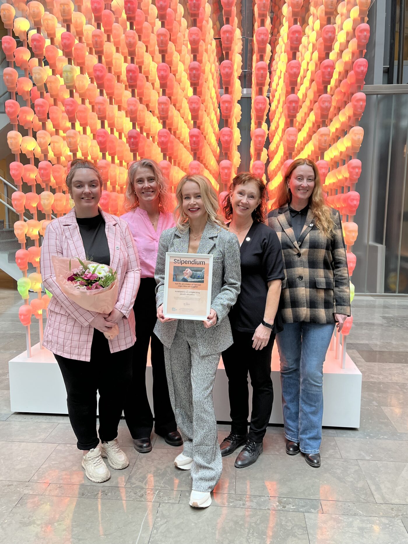 Storasysters medarbetare tillsammans med en representant från Skandia – håller i stipendiet och blommor